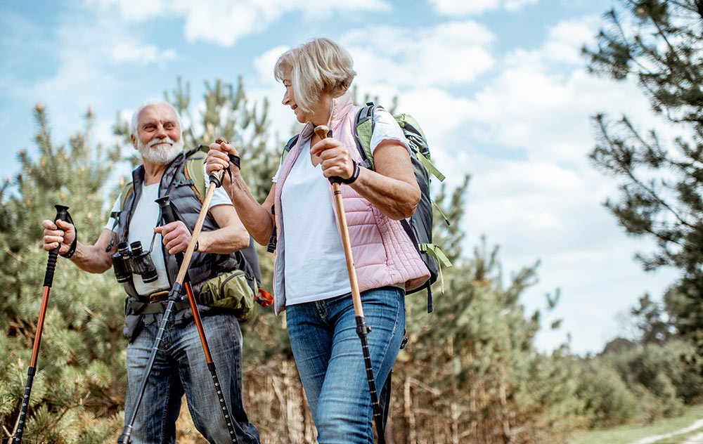 Osteoporose vorbeugen - Glückliches Senioren Paar beim Wandern