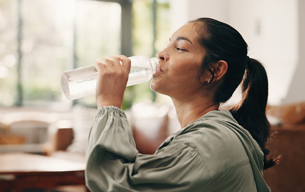 Schaubild zeigt Frau, welche aus Glasflasche trinkt - symbolisiert plastikfrei leben im Alltag