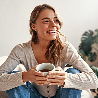 Schaubild zeigt lächelnde Frau, die Tasse in der Hand hält