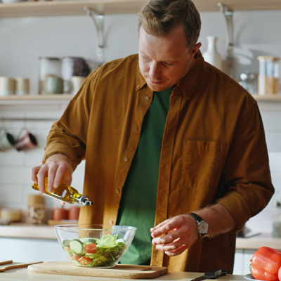 Bild zeigt zeigt Mann beim Kochen. Lebensmittel sind nicht in Plastik verpackt, symbolisiert wie man plastikfrei kochen kann.